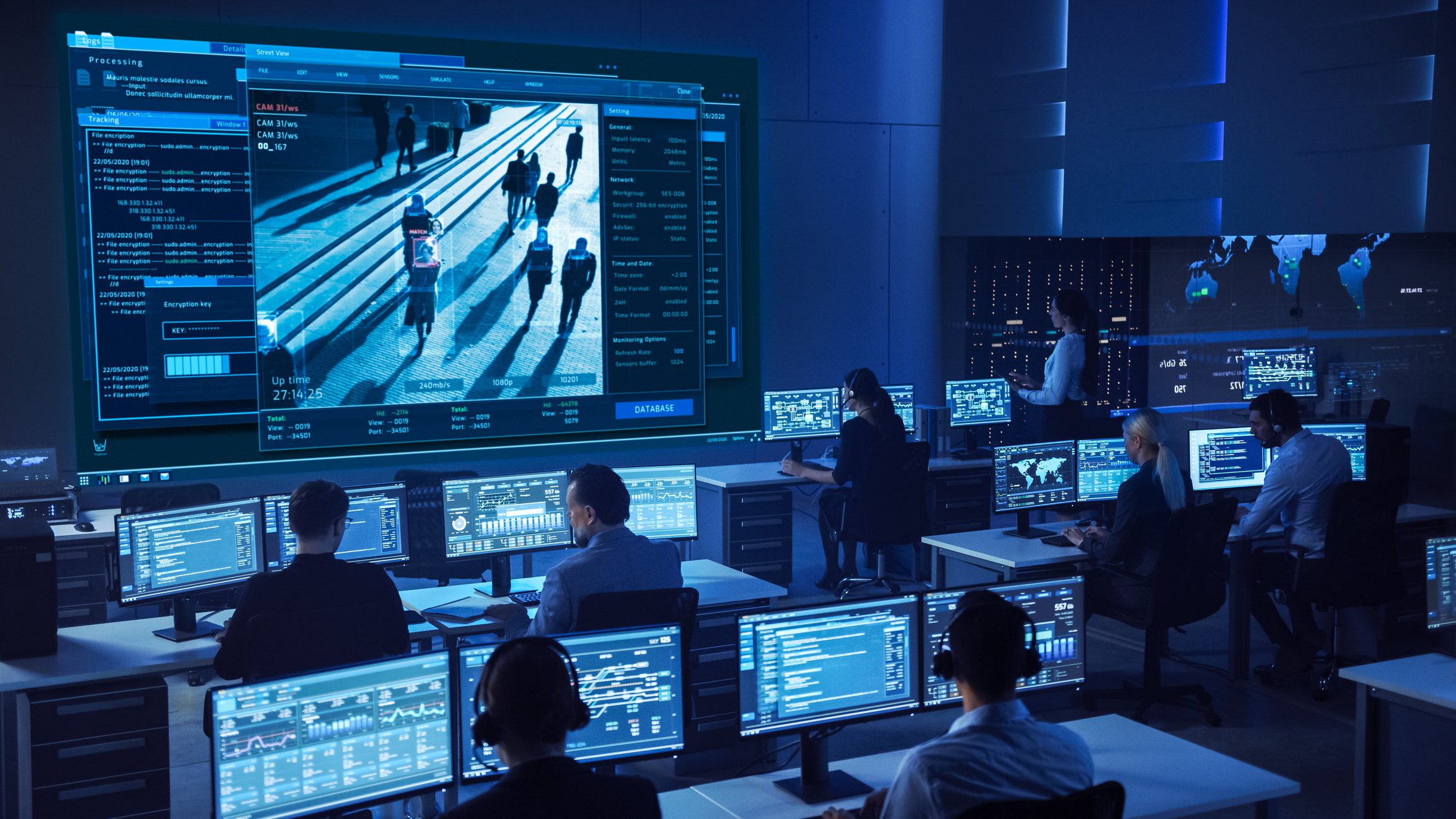 Team of Professional Cyber Security Data Science Engineers Work on Surveillance Tracking Shot of People Walking on City Streets. Big Dark Control and Monitoring Room with Computer Displays. Cyber Center